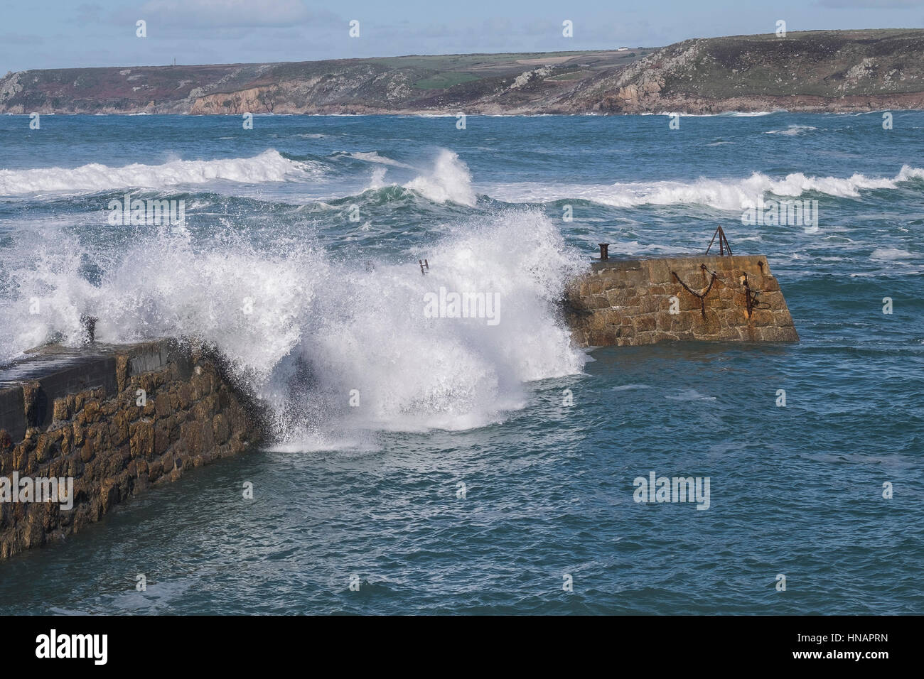 Starke Winde fahren Wellen über der Oberseite von der Mole in Sennen Cove, Cornwall, England. Großbritannien Wetter. Stockfoto