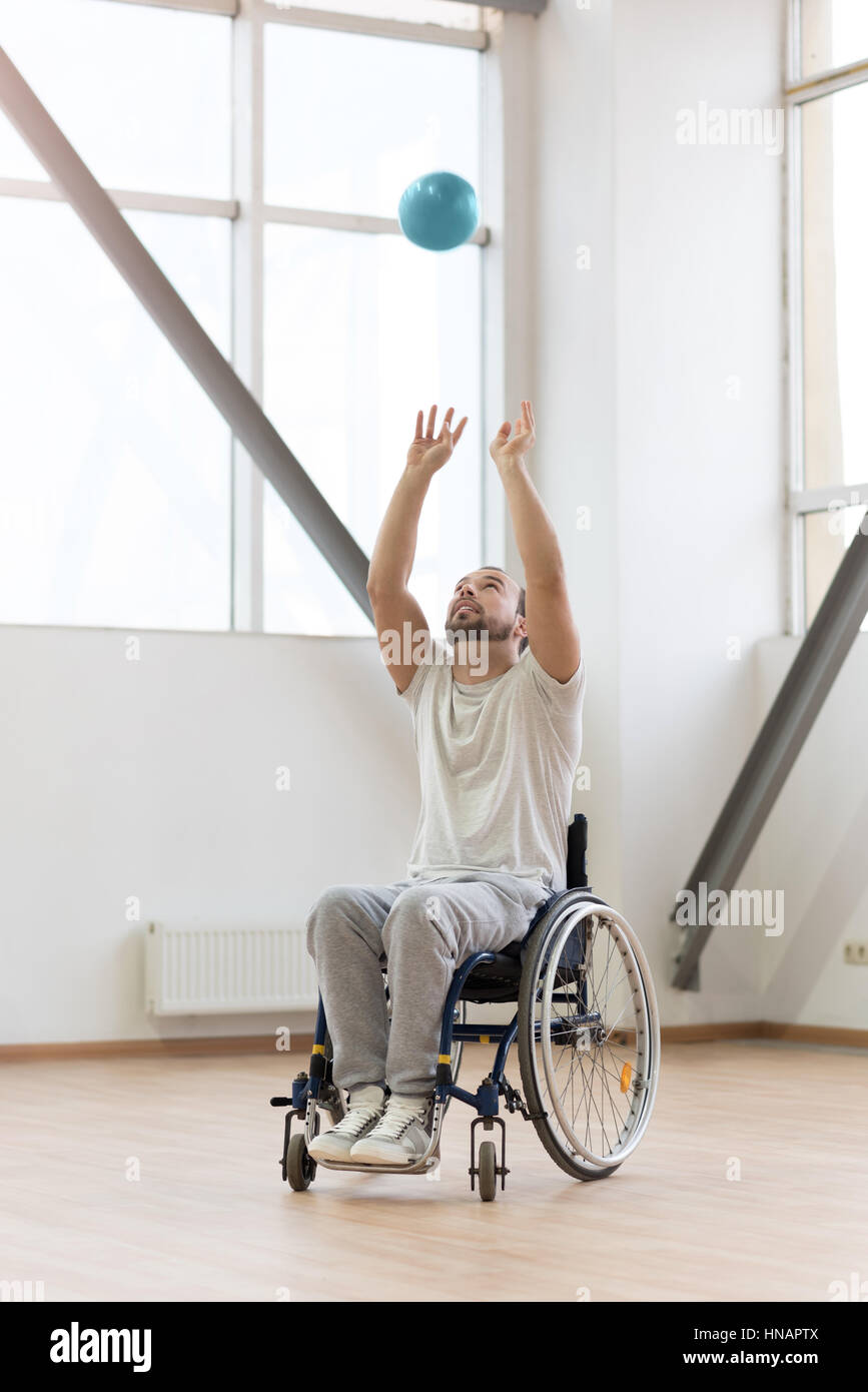 Begeistert junge Behinderte werfen den Ball in der Turnhalle Stockfoto