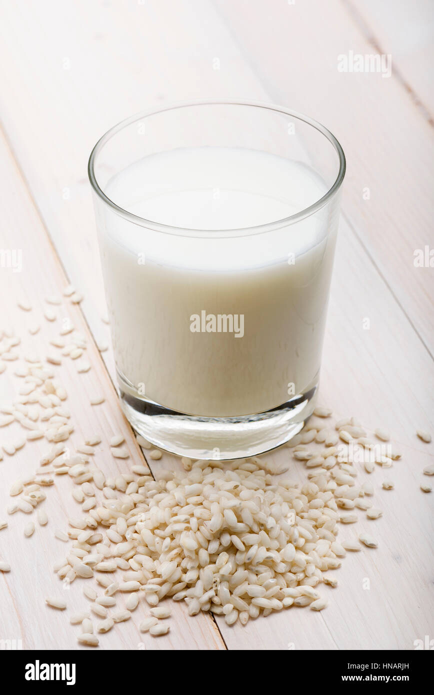 Glas Reismilch mit Reiskörner auf Holztisch Stockfoto