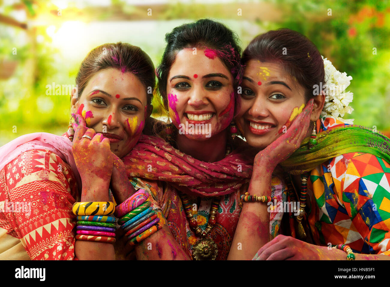 Porträt von drei indischen Teenager feiern Holi-Fest mit traditionellen Trachten und Schmuck Stockfoto