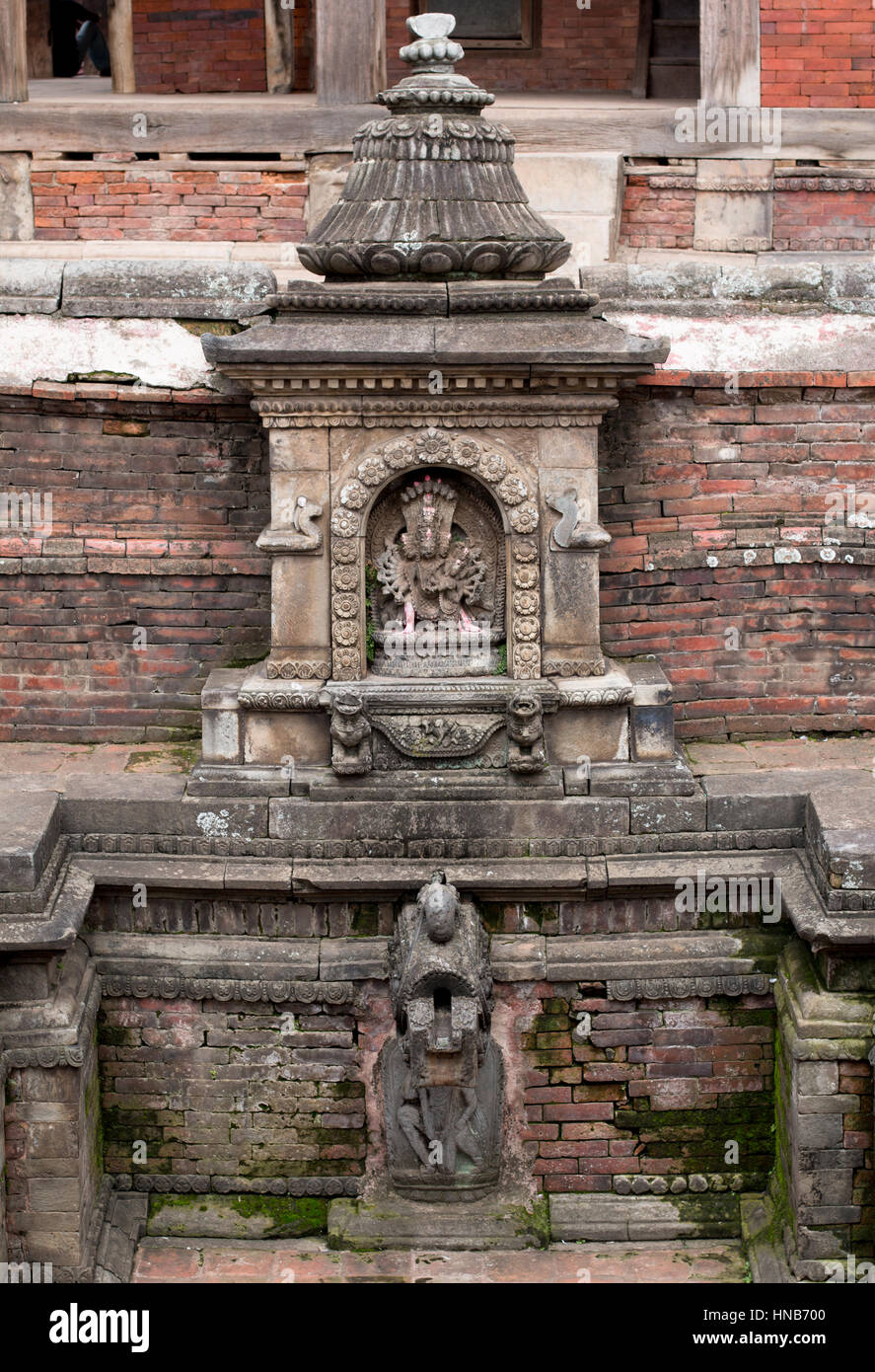Steinbildhauerei von Vishnu, einem Hindu-Gott, in einem Tempel in Bhaktapur, Kathmandu, neben dem Wasserteich Stockfoto