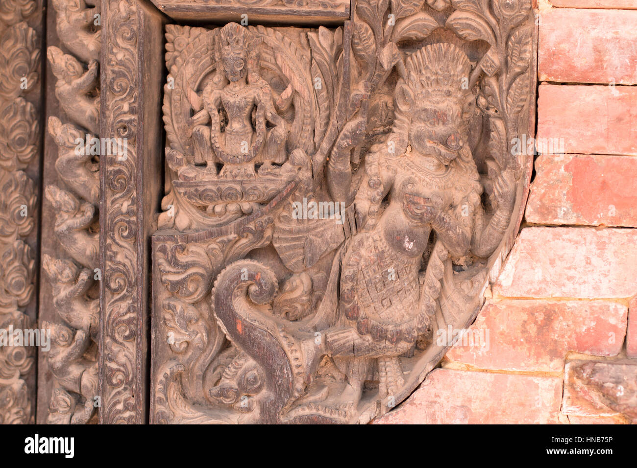 Holzschnitzerei von Hindu-Gottheiten und himmlische Nymphen schmücken die Wände eines Gebäudes in Bhaktapur, Kathmandu Stockfoto