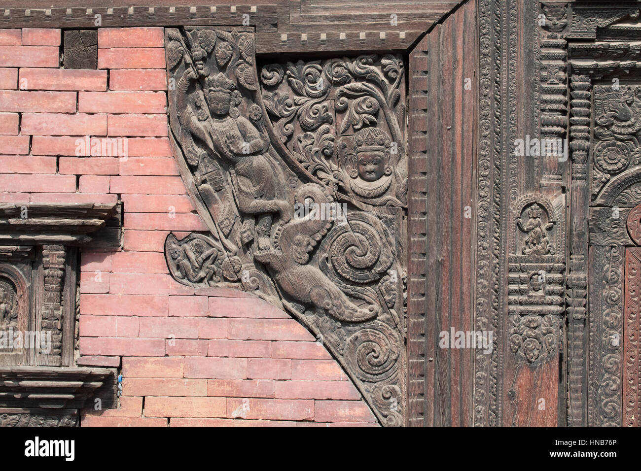 Holzschnitzerei von Hindu-Gottheiten und himmlische Nymphen schmücken die Wände eines Gebäudes in Bhaktapur, Kathmandu Stockfoto