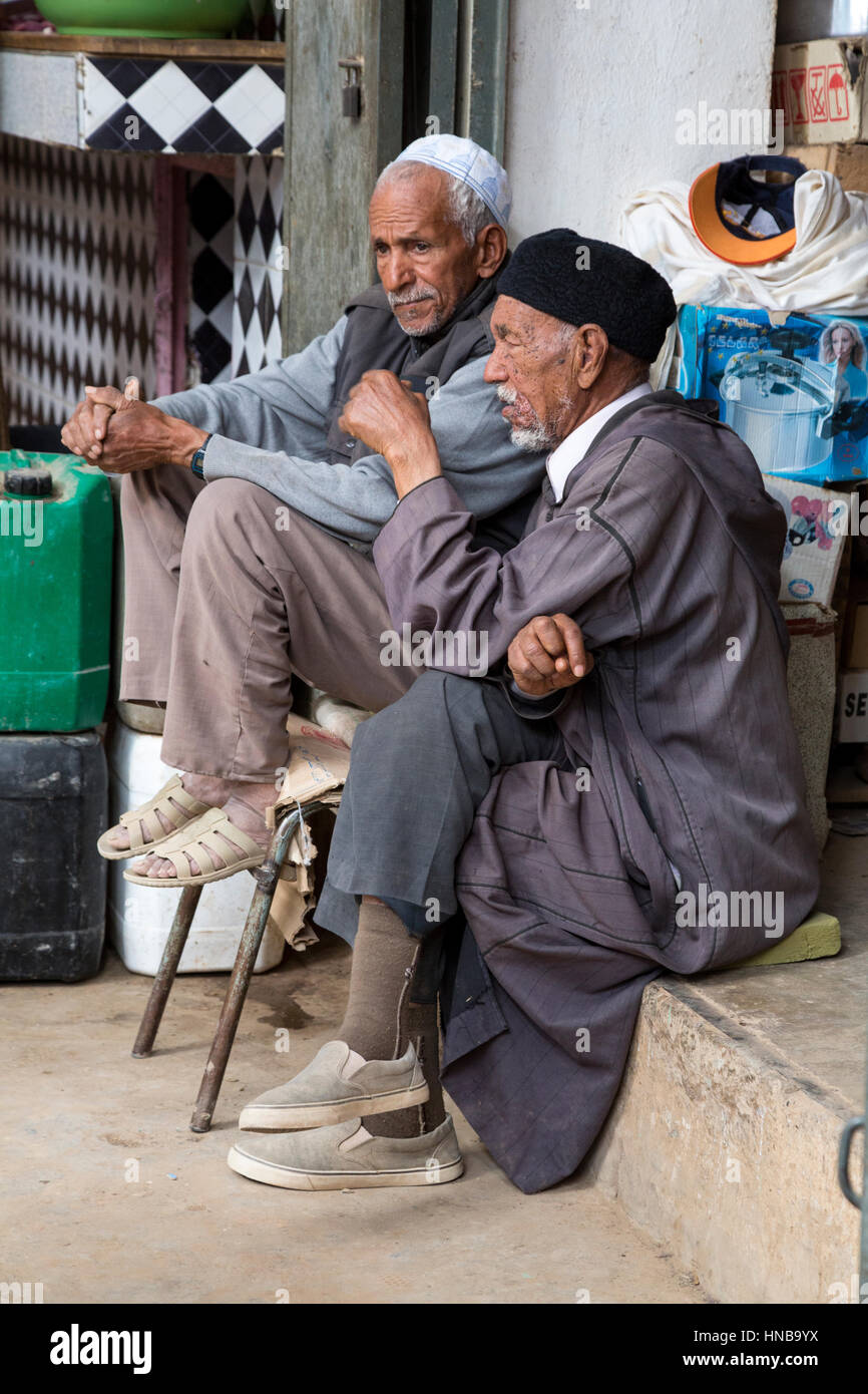 Rissani, Marokko.  Markt, zwei Männer mittleren Alters beisammen sitzen. Stockfoto
