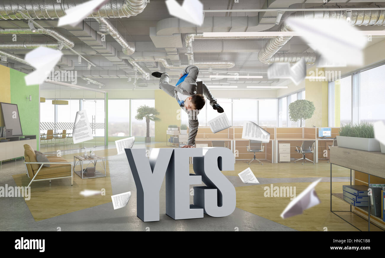 Fröhliche Jungunternehmer tanzen in seinem Büro. Mixed-media Stockfoto