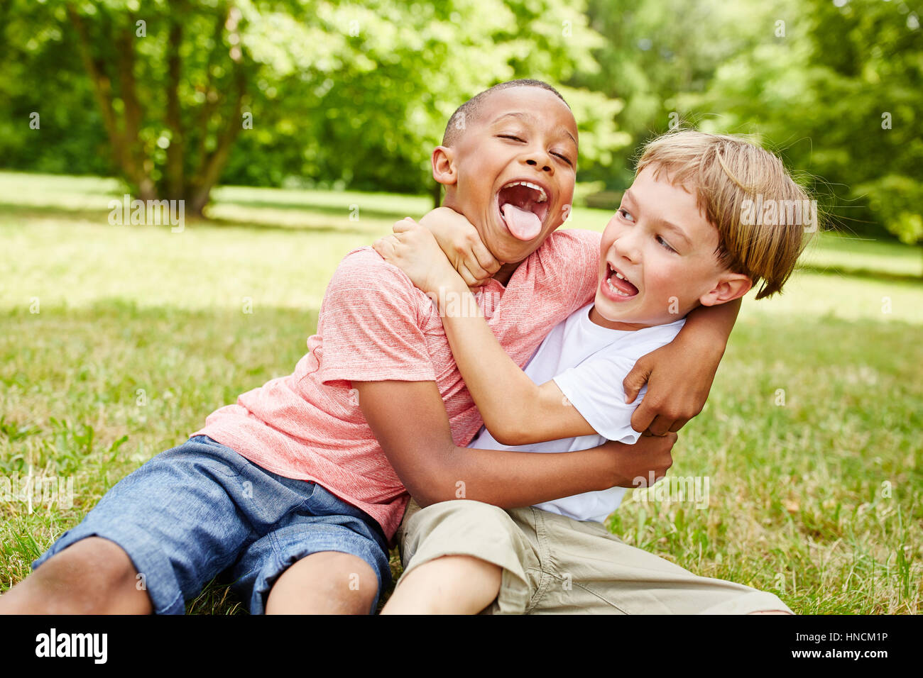 Zwei jungen haben Spaß im Park und Ringen beim Lachen Stockfoto