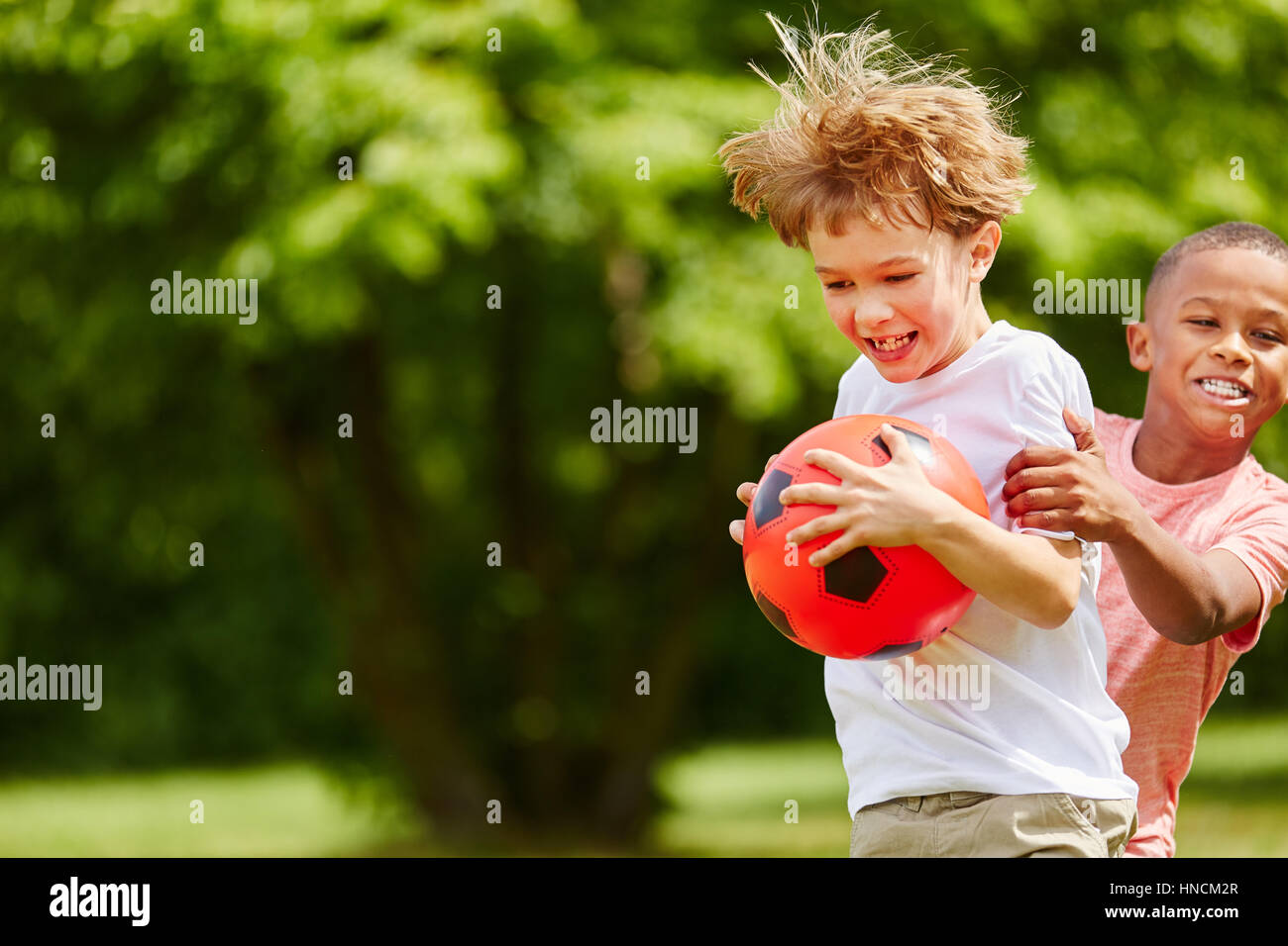 Zwei jungen raufen während Fußballspiel und Spaß haben Stockfoto