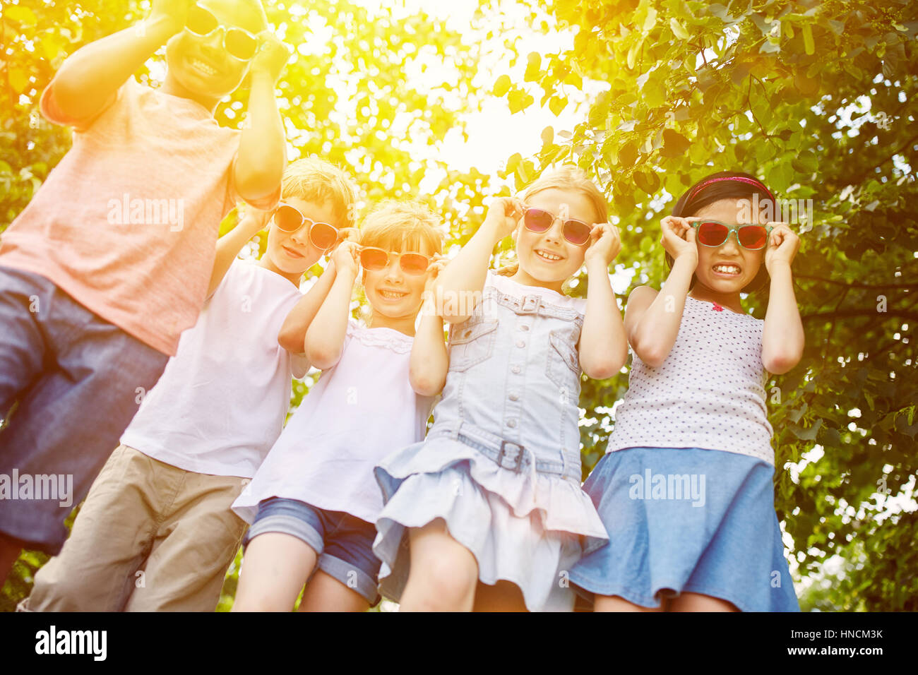 Coole Gruppe von Kindern als interracial Freunde mit Sonnenbrille im Sommer Stockfoto