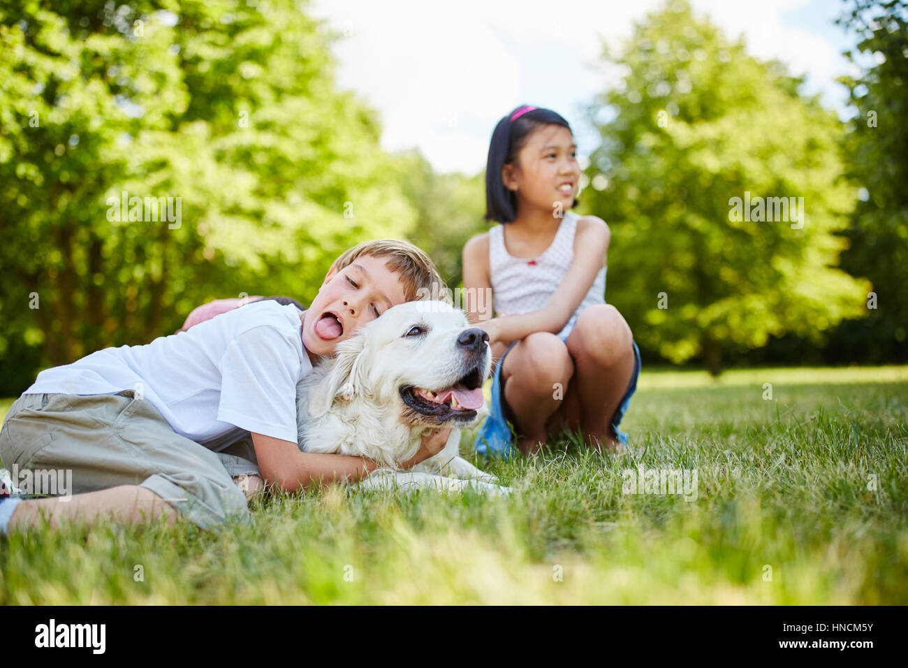 Kind umarmt Golden Retriever Hund mit Zuneigung und Liebe Stockfoto