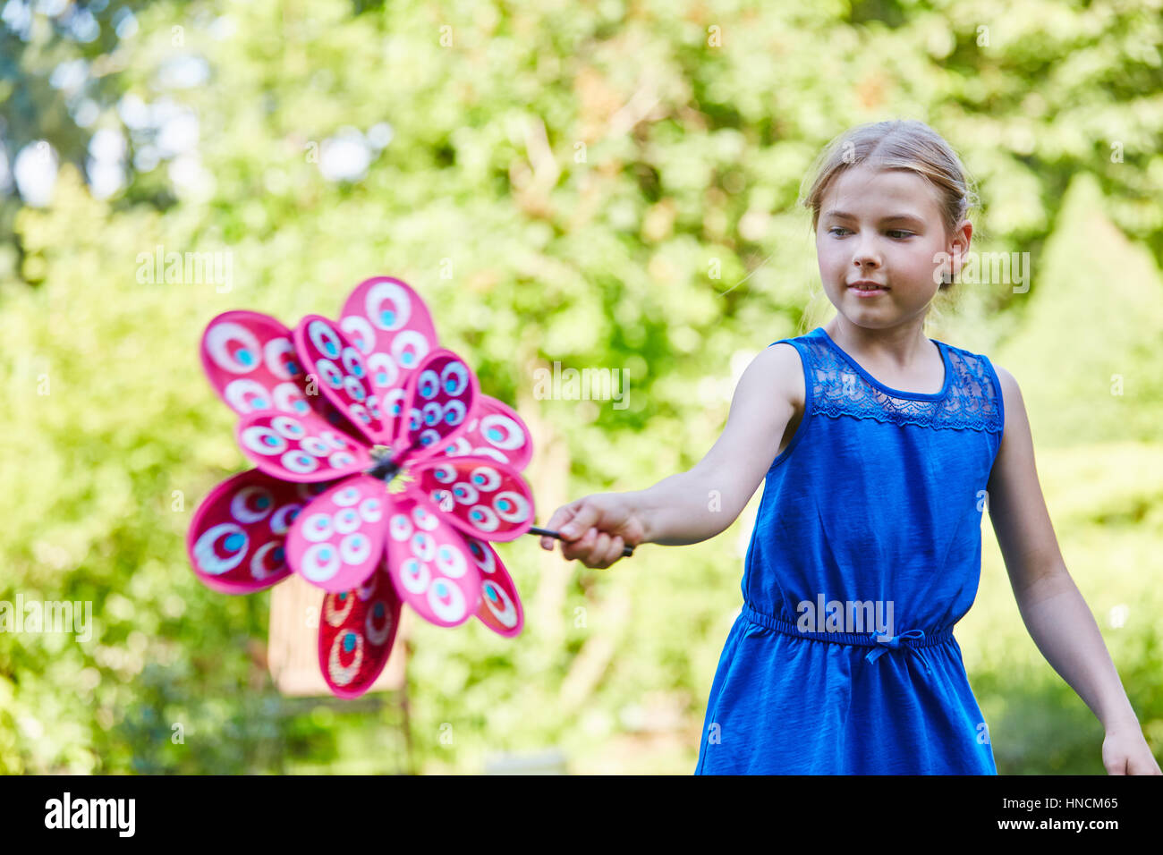 Mädchen mit Windmühle im Sommer unbeschwert spielen und hat Spaß Stockfoto