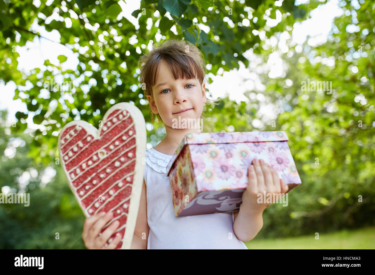 Kind mit Geburtstagsgeschenk als Überraschung auf Geburtstagsparty Stockfoto