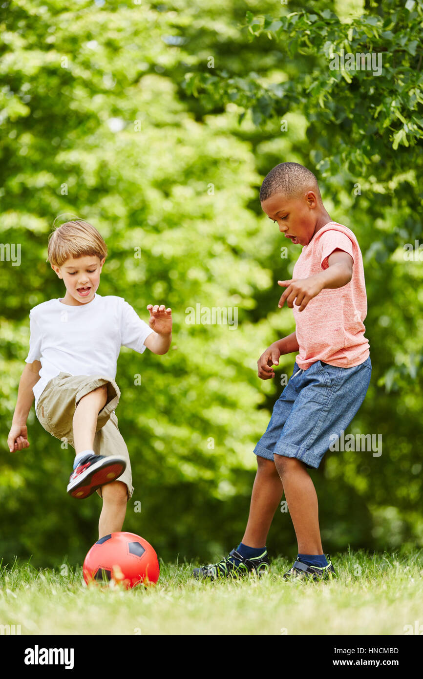 Zwei Jungs als Freunde spielen Fußball im Park im club Stockfoto