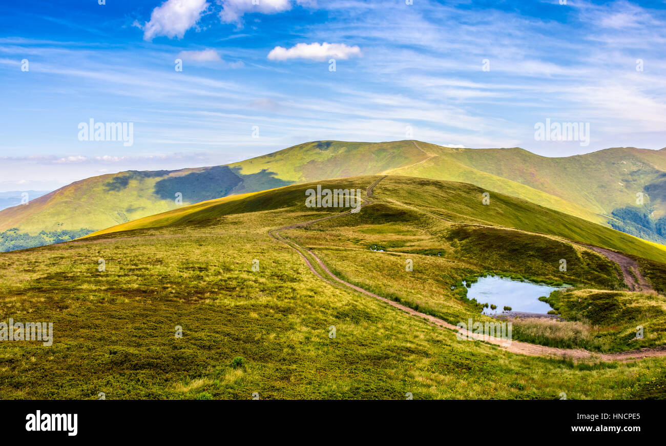 Sommerlandschaft in Bergen mit kleinen Sumpf zwischen zwei Pfad am Hang Stockfoto