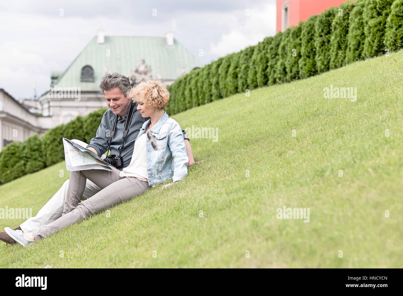 Paar mittleren Alters Lesung Karte beim Sitzen im park Stockfoto