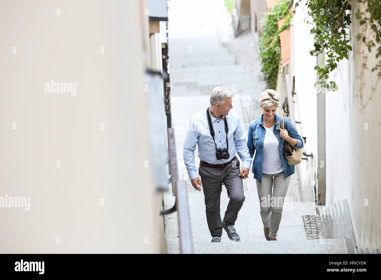 Vogelperspektive Blick auf Paar mittleren Alters, die Hand in Hand beim Klettern Schritte im freien Stockfoto