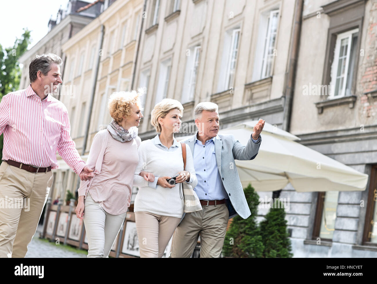 Mann zeigt etwas an Freunde während des Gehens in Stadt Stockfoto