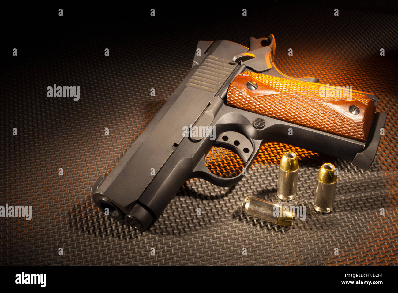 Semi automatische Pistole mit Patronen und orange Beleuchtung Stockfoto