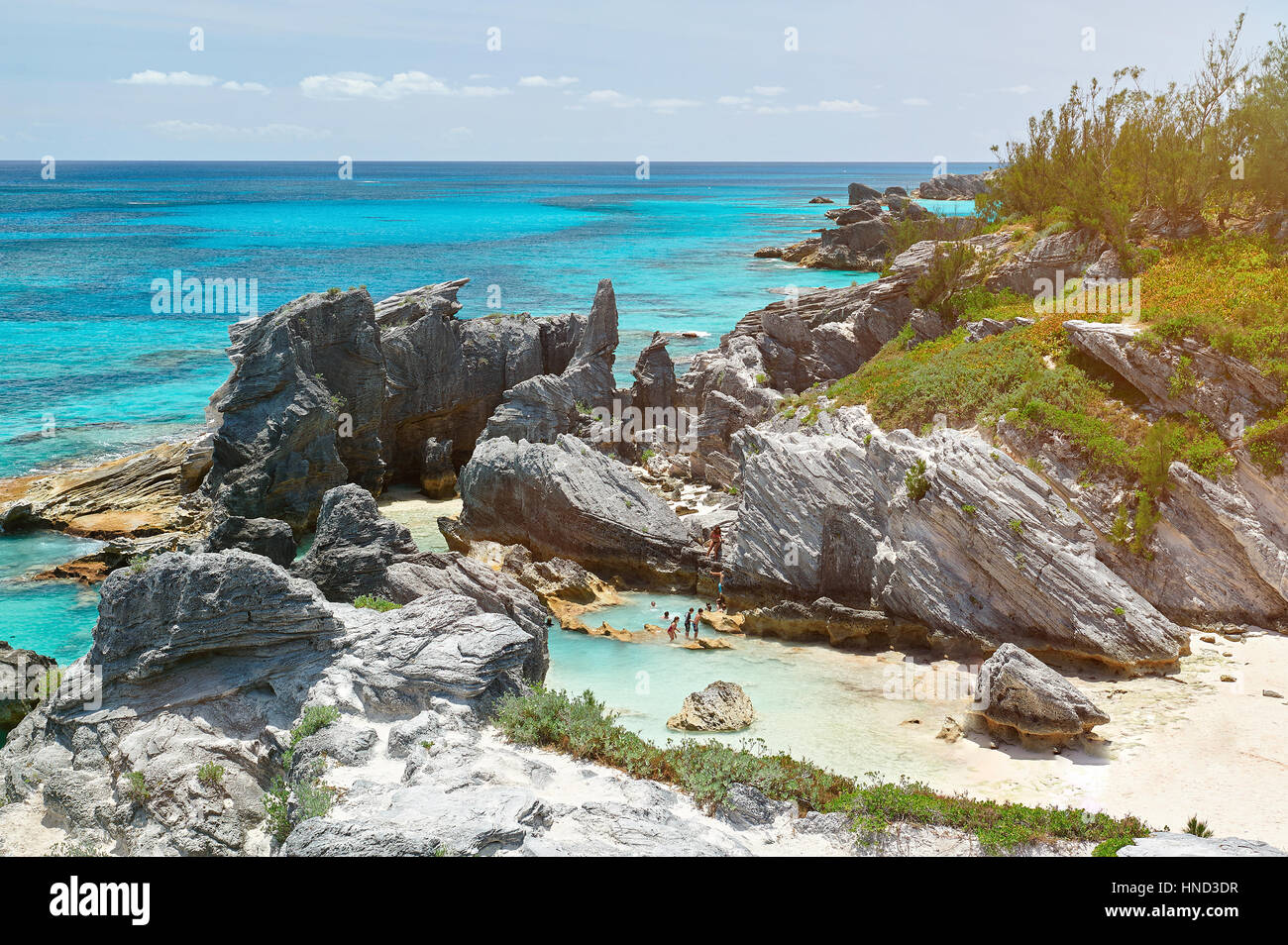 Felsige Bucht mit blauem Wasser in Bermuda Insel. Menschen im Urlaub an der Atlantikküste Stockfoto