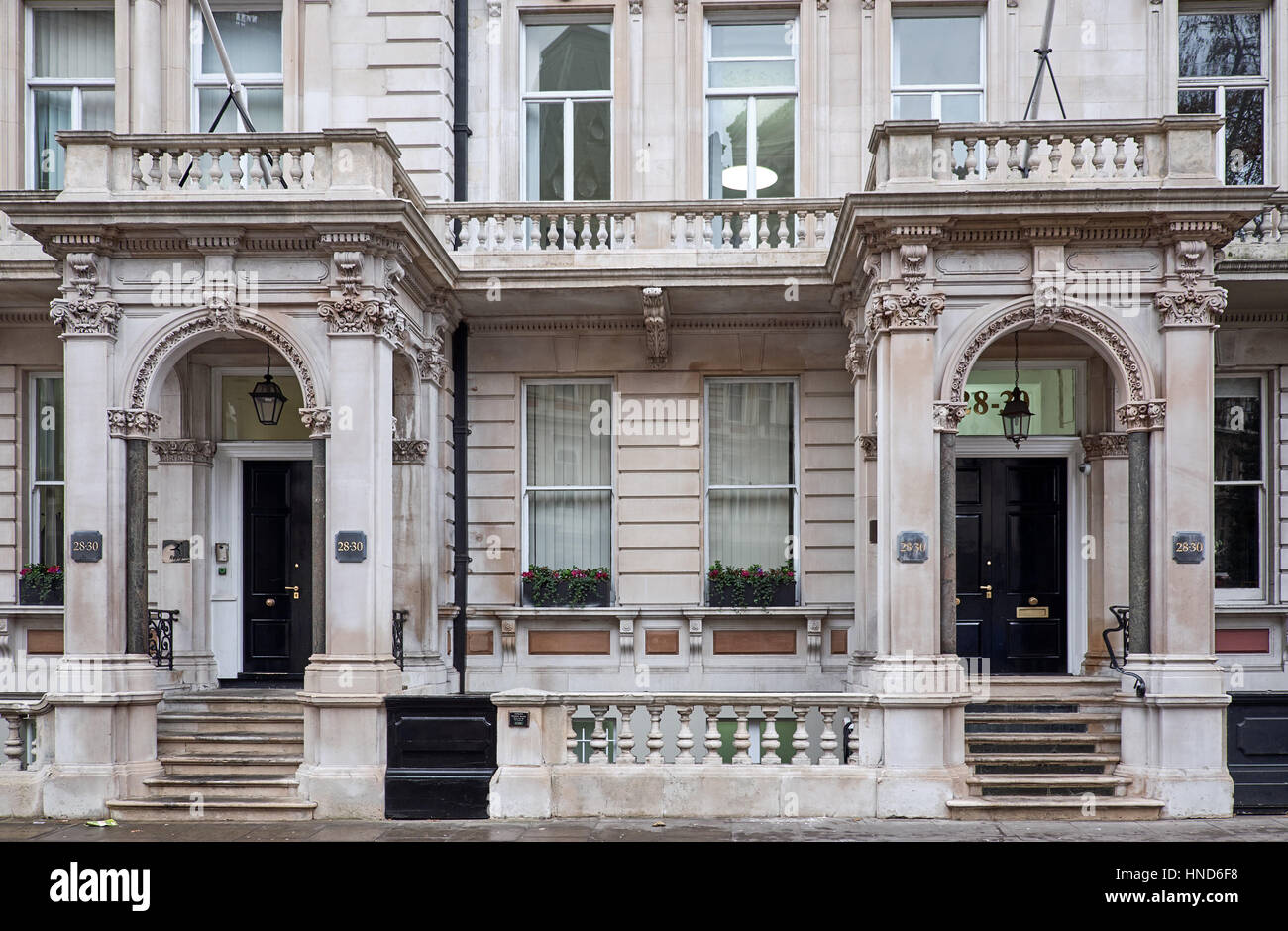 Verzierte Fassade mit aufwendigen Dekorationen rund um Eingang Tierheim, unterstützt auf Spalten eines Gebäudes in London City Stockfoto