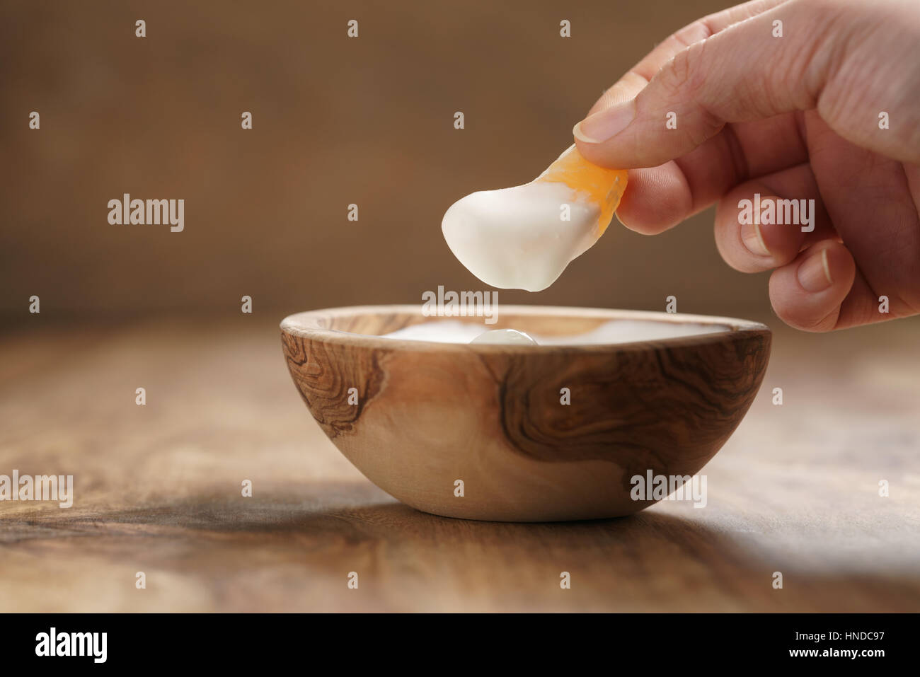Essen Bio-Joghurt mit Mandarine aus Holz Schale, flachen Fokus Stockfoto