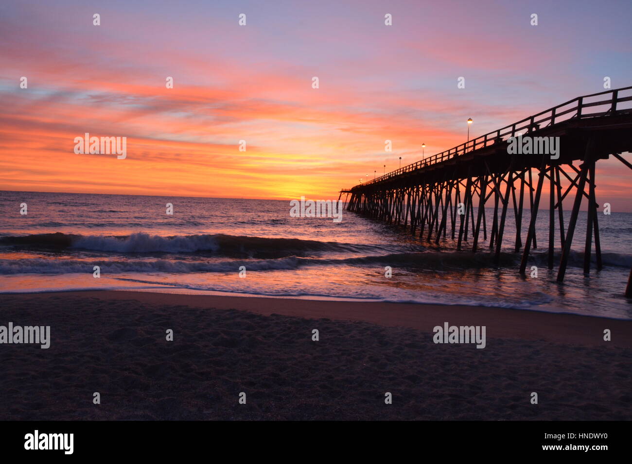 Sonnenaufgang über der Seebrücke in Kure Beach, North Carolina Stockfoto