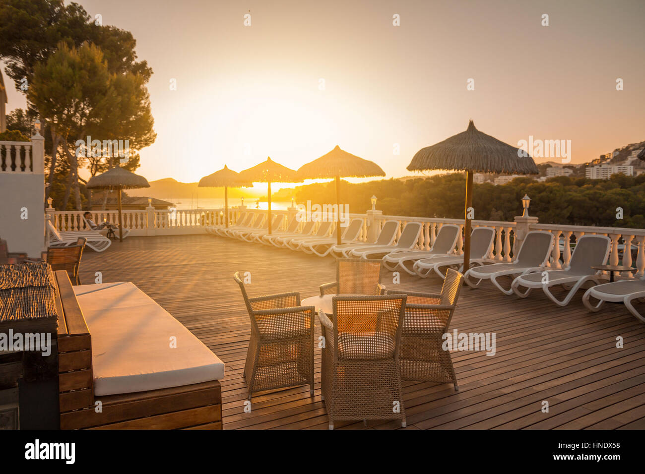 Tisch und Stühle im Sonnenuntergang auf der Terrasse des Sommer-Ferien-resort Stockfoto