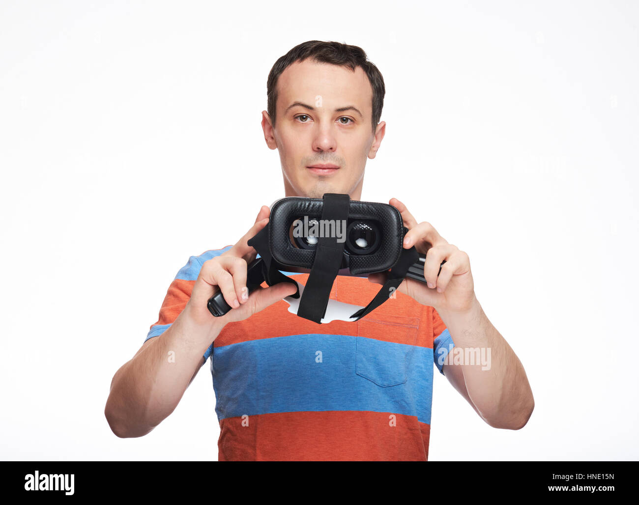 Junger Mann halten virtual-Reality-Brille isoliert auf weißem Hintergrund Stockfoto