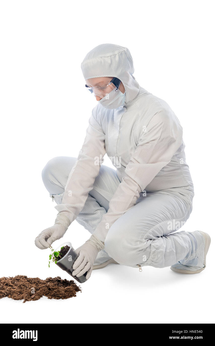 Frau in einem Schutzanzug hält Experimente mit Pflanzen auf einem weißen Hintergrund Stockfoto