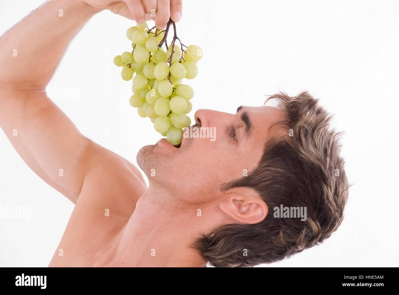 Model Release, Mann, 35 +, Isst Gruene Weintrauben - Trauben isst der Mensch Stockfoto