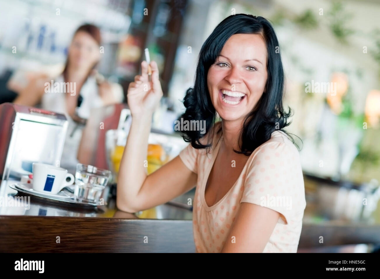Model Release, Lachende, Junge Frau Sitzt eine der Theke Im Kaffeehaus Und Raucht - junge Frau Rauchen in der cafeteria Stockfoto