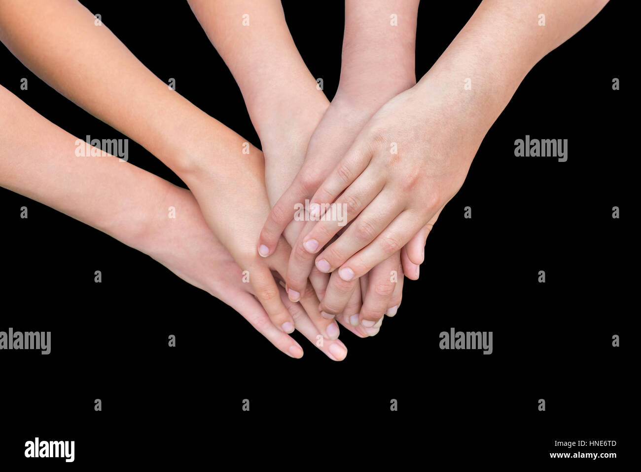 Fünf arme Mädchen mit Hände übereinander auf schwarzem Hintergrund isoliert Stockfoto