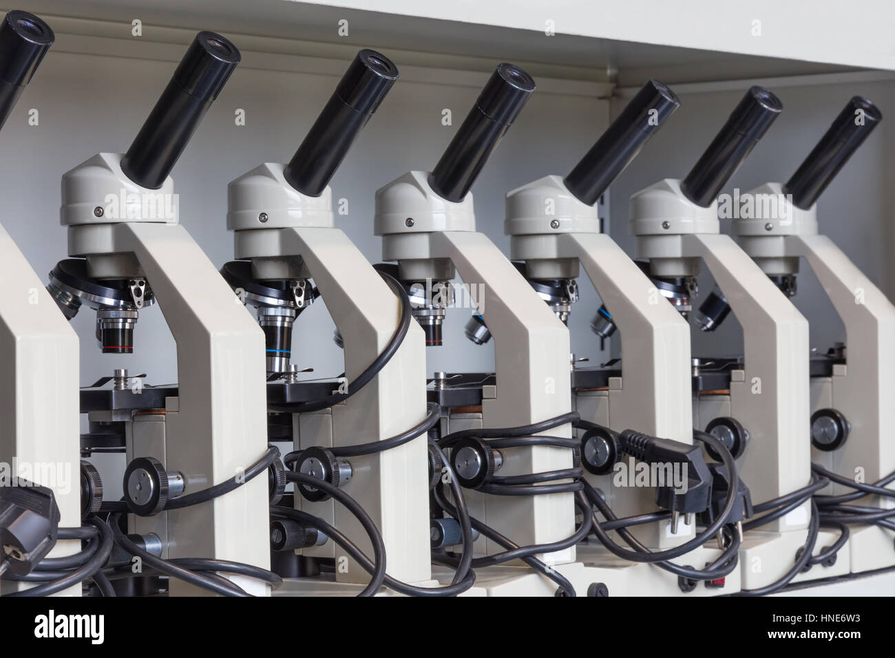 Schrank mit Reihe von Mikroskopen auf Regal in Biologie in der Sekundarstufe Stockfoto