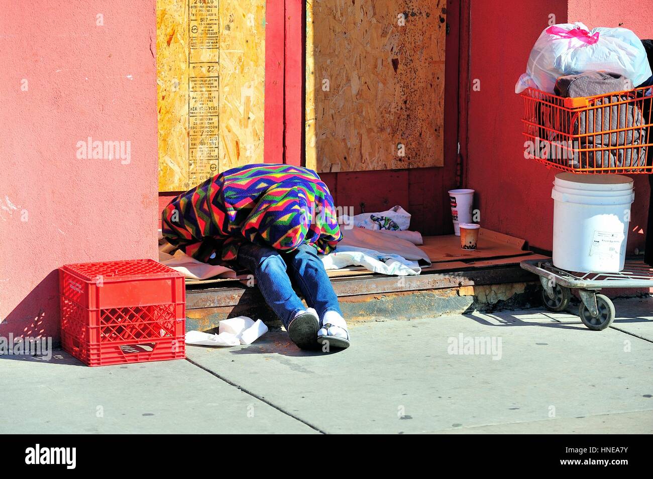 Ein obdachloser Mann unter seinen Sachen in einem Geentert, storefront Eingangsbereich in Chicagos Chinatown Nachbarschaft. Chicago, Illinois, USA. Stockfoto