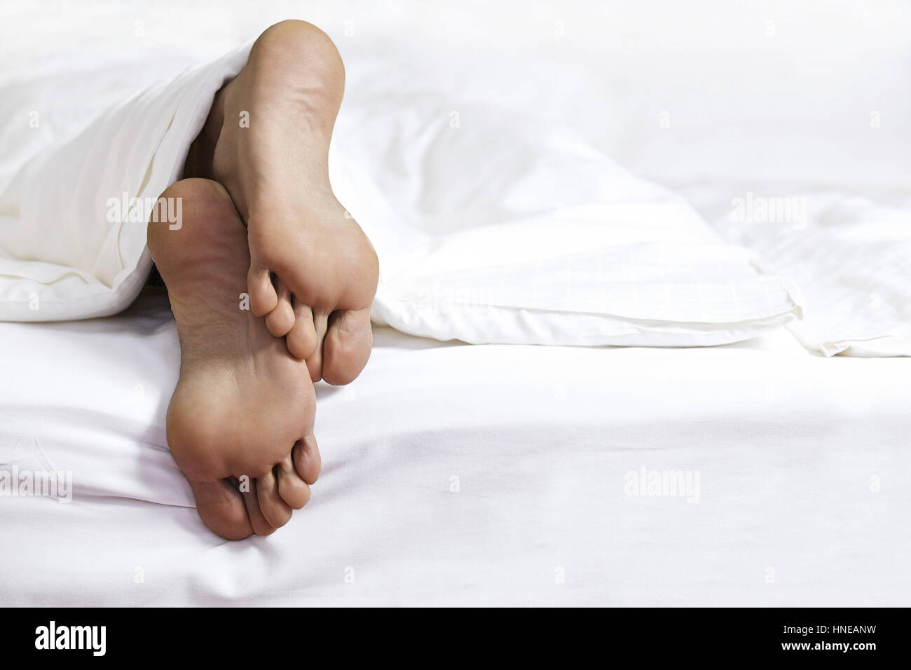 Jemandes Fuß im Bett Stockfoto