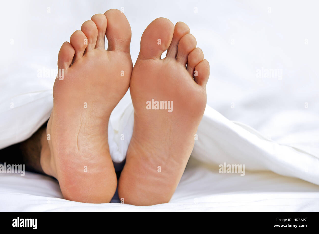 Jemandes Fuß im Bett, Nahaufnahme Stockfoto