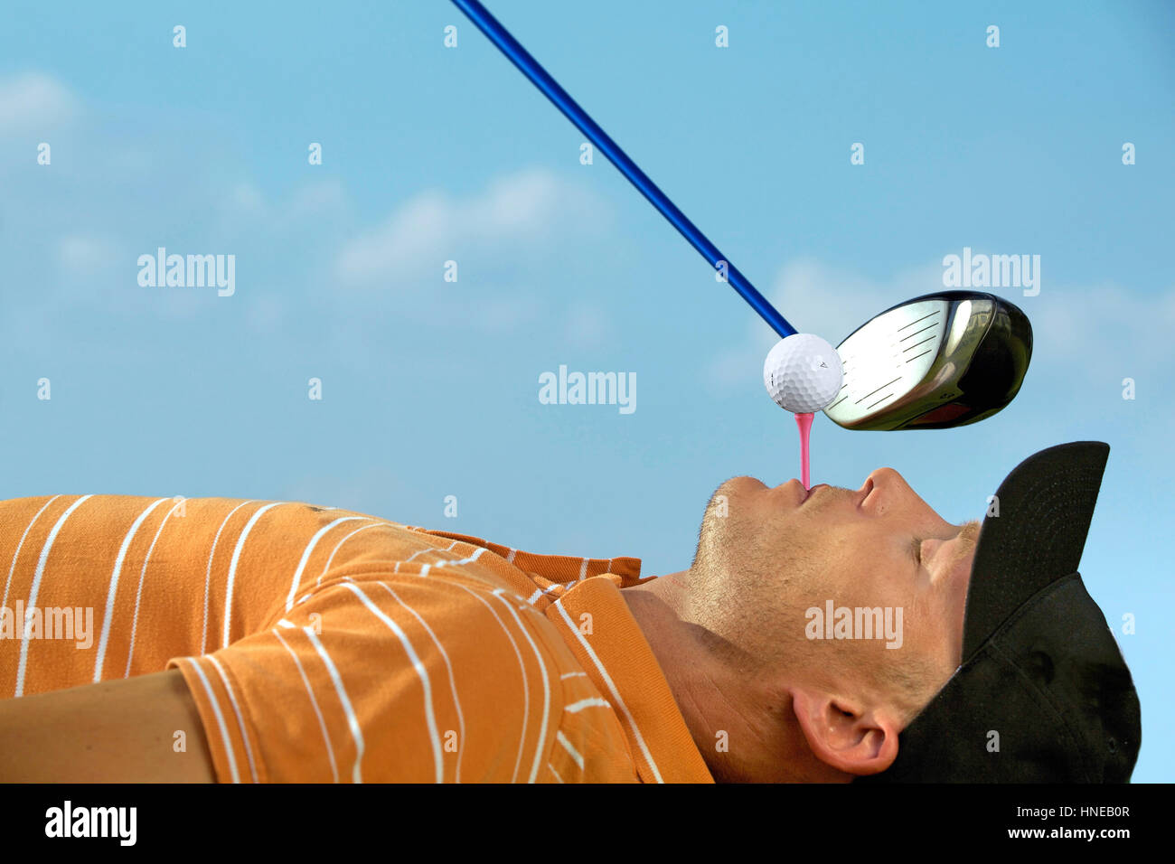 Mann Ausgleich Golfball am Abschlag in den Mund Stockfoto