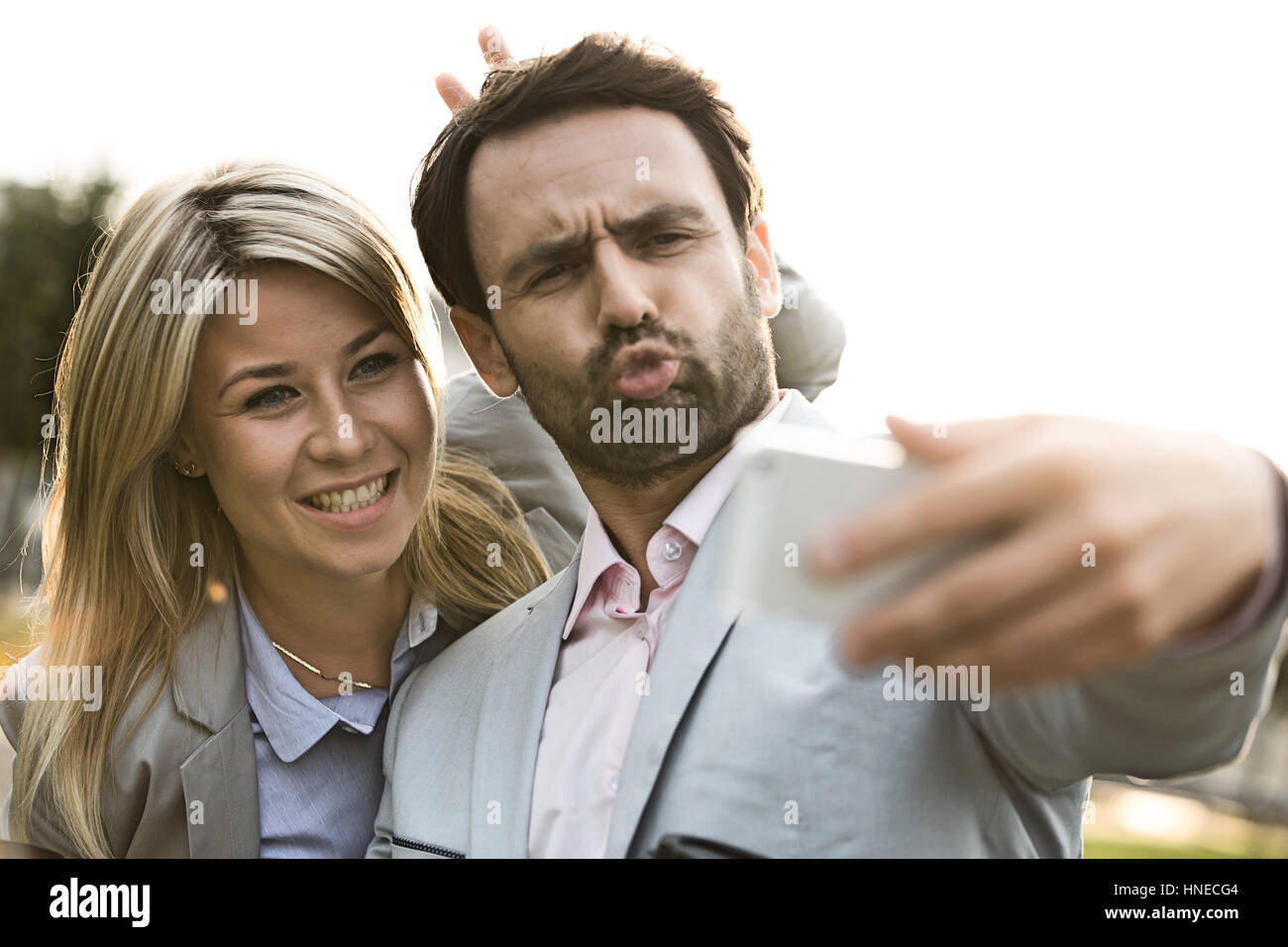 Spielerische Geschäft paar nehmen Selfie im Freien an sonnigen Tag Stockfoto
