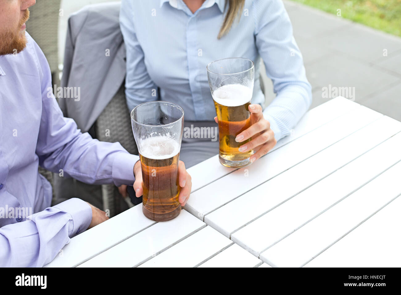 Mittelteil von Geschäft paar hält Biergläser im Restaurant unter freiem Himmel Stockfoto