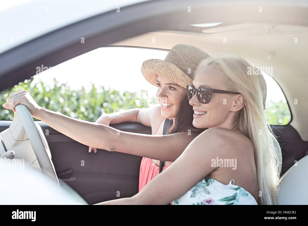 Glücklich Freundinnen im Auto an sonnigen Tag genießen Stockfoto