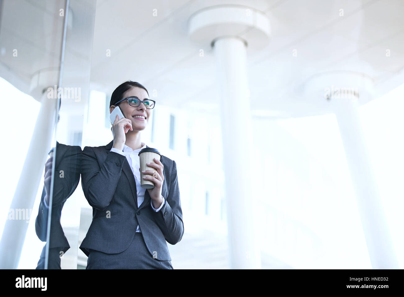 Geschäftsfrau mit Handy halten Sie Einweg-Cup im freien Stockfoto