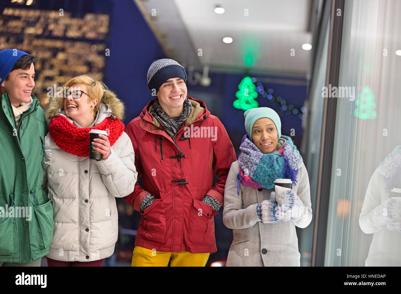 Glücklich multiethnischen Freunde im Winter tragen zu Fuß in die Stadt während der Dämmerung Stockfoto