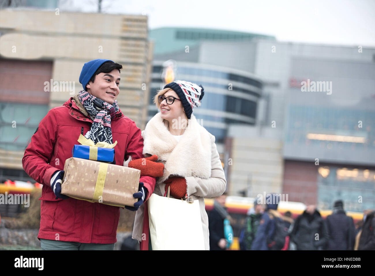 Brautpaar mit Geschenken und Einkaufstaschen zu Fuß in die Stadt im winter Stockfoto
