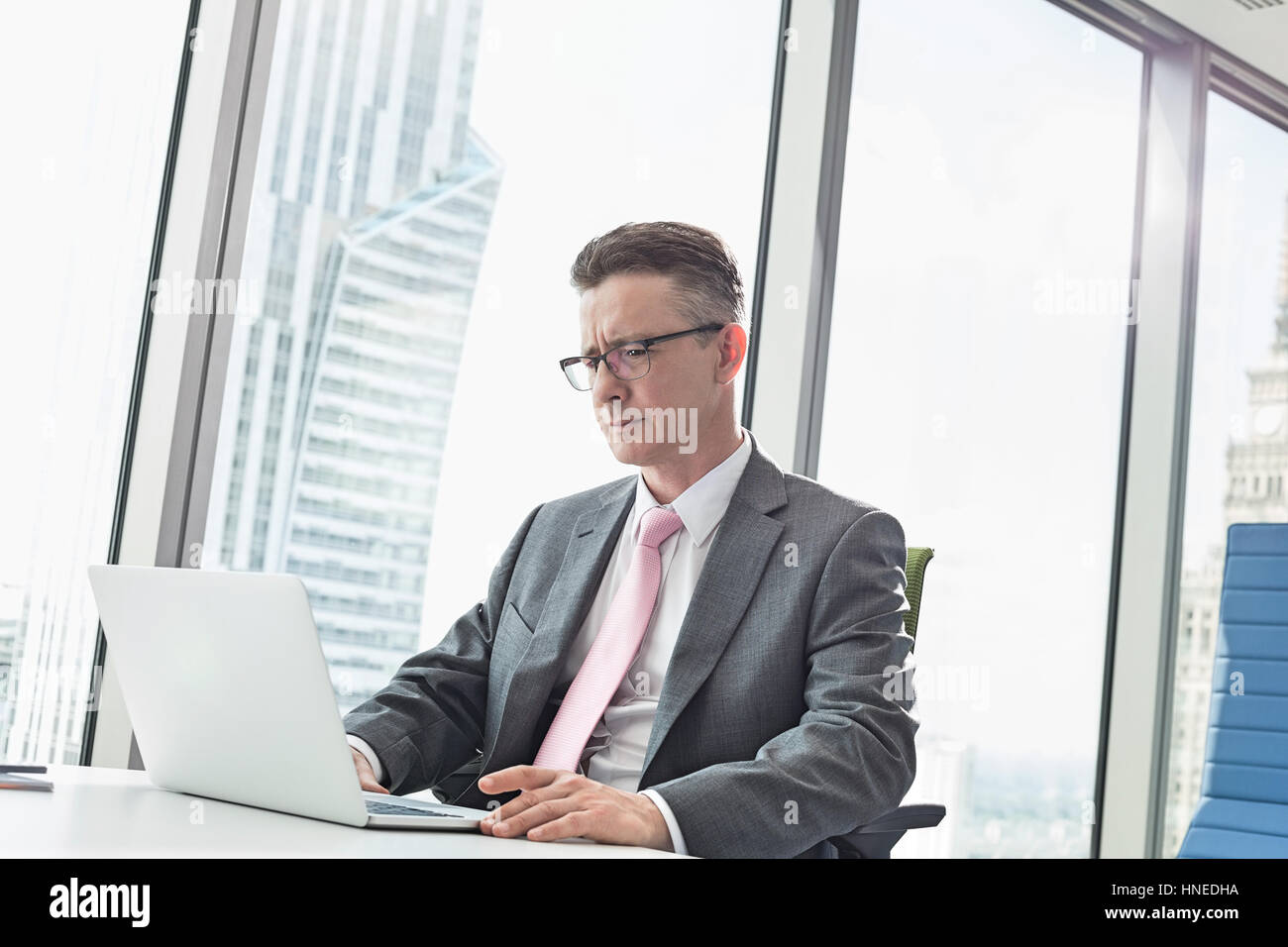 Reife Geschäftsmann mit Laptop im Büro Stockfoto