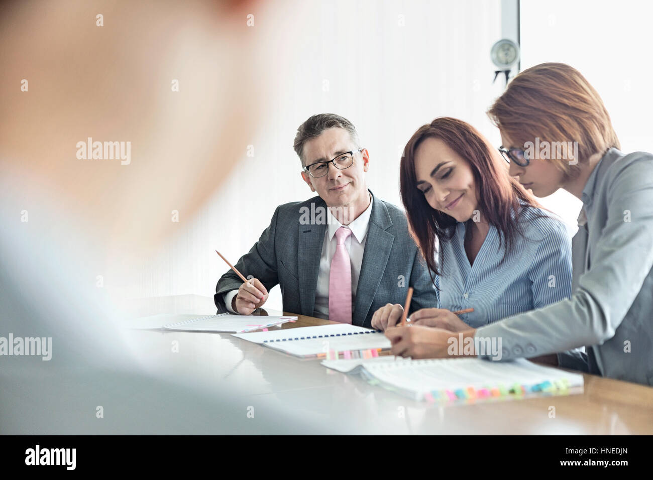Geschäftsleute, die gemeinsam am Konferenztisch Stockfoto