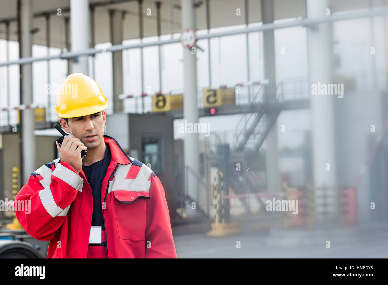 Männliche Arbeiter mit Walkie-talkie im Frachthafen Stockfoto