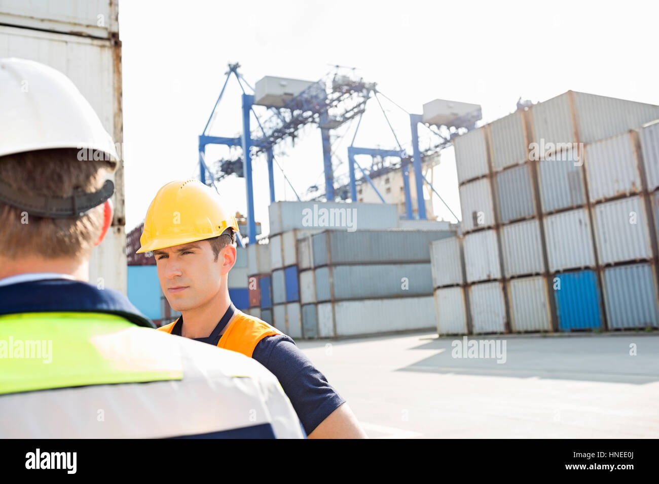 Männliche Arbeitnehmer stehen im Frachthafen Stockfoto