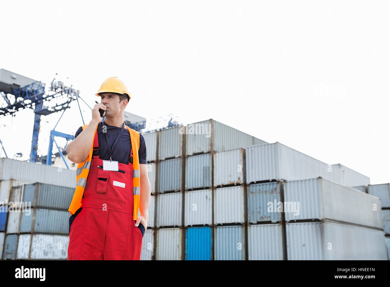 Männliche Arbeiter mit Walkie-talkie im Frachthafen Stockfoto