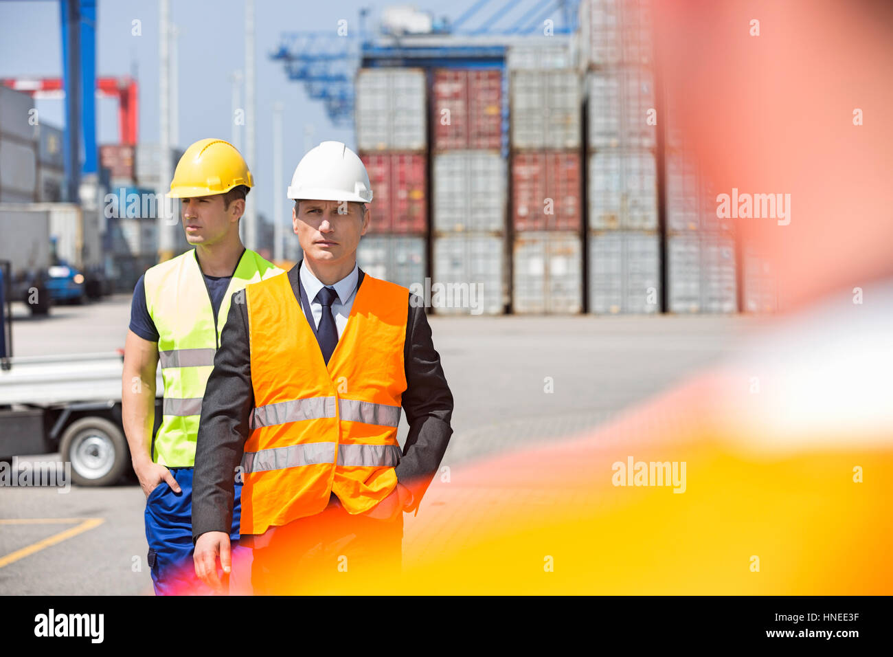 Männliche Arbeiter zu Fuß im Frachthafen Stockfoto