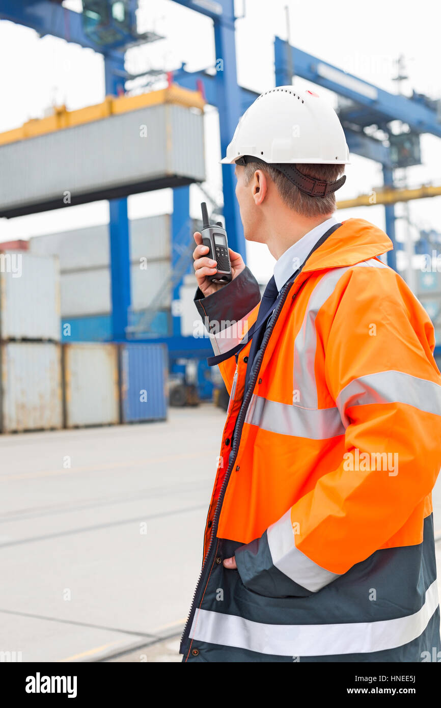 Mann mittleren Alters mit Walkie-talkie im Frachthafen Stockfoto