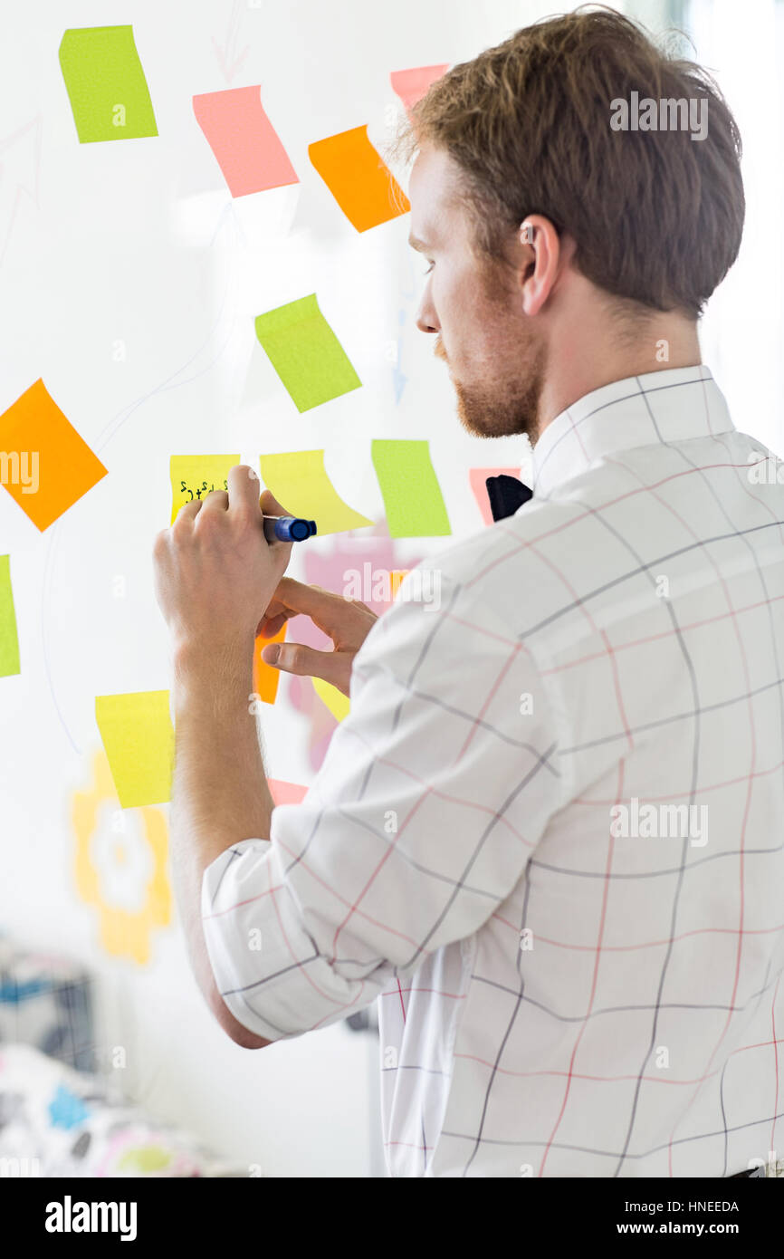 Rückansicht der Geschäftsmann auf klebrigen Papier bei Kreativbüro schreiben Stockfoto